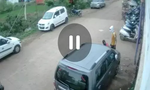 महिला से चेन स्नैचिंग का वीडियो: बाइक से जा रहे युवक थोड़ी देर रुके, फिर मौक़ा देख गले से चेन खींच हुए फरार