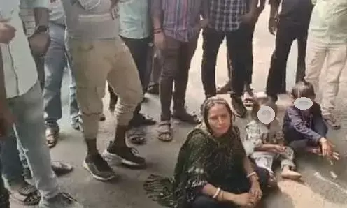 Dhanbad Crime News: धनबाद में पति-सास की प्रताड़ना से परेशान महिला व्यस्त सड़क पर तीन बच्चों के साथ धरने पर बैठी