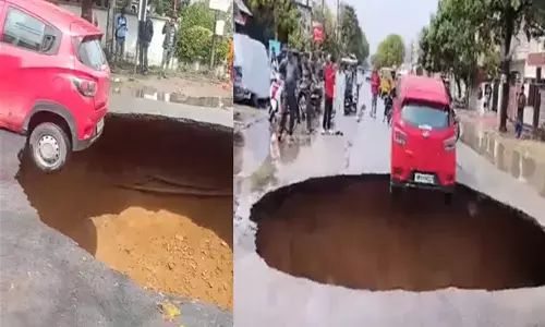 UP News: लखनऊ में सड़क धंसने से बना 20 फीट गहरा गड्ढा, लटकती रही कार, PWD ने बताई ये वजह